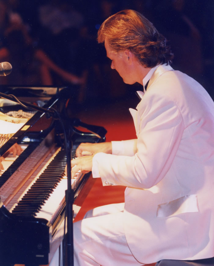 Jon England performing at piano on stage